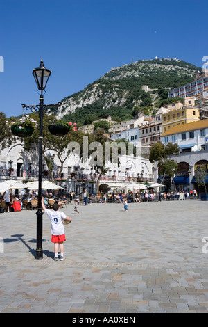 Young boy wearing football strip taking a rest in Casemates Square Gibraltar Stock Photo