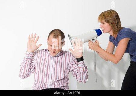 Man shouting at man through loudspeaker Stock Photo