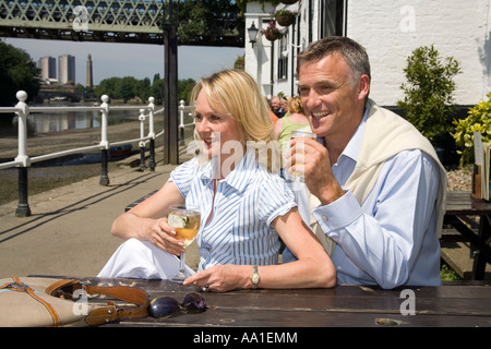 Couple at Strand on the Green outside the Bulls Head Pub Chiswick London Stock Photo