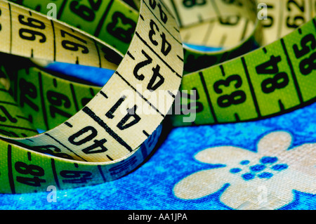 Tape measure on textile with floral pattern, close-up Stock Photo
