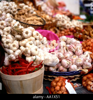 Garlic bulbs on strings, red chillies, dried giner and shallots heaped on a stall at Borough Market food market in baskets London UK KATHY DEWITT Stock Photo