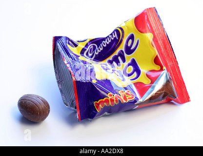 A packet of cadburys mini creme eggs with one egg out of packet against a white background Stock Photo
