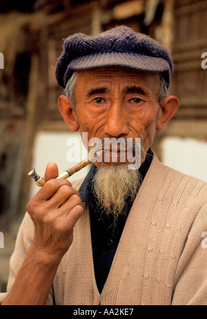 1, one, Chinese man, Bai man, ethnic minority, old man, smoking tobacco, smoking pipe, eye contact, front view, Shaping, Yunnan Province, China Stock Photo