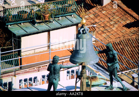 Italy, Venice, iron bell and statues on roof, rooftops in background, elevated view Stock Photo