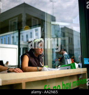 A woman in a restaurant window at Portobello Road Market Notting Hill Gate West London England UK Stock Photo