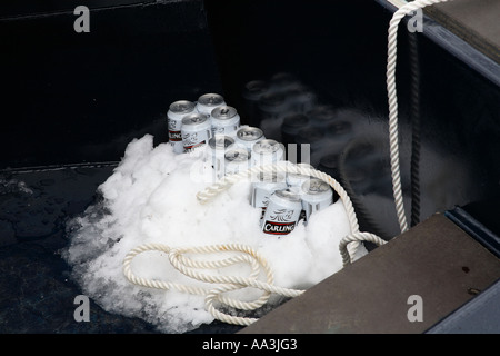 Lager cans in snow being kept cool on a canal boat Stock Photo