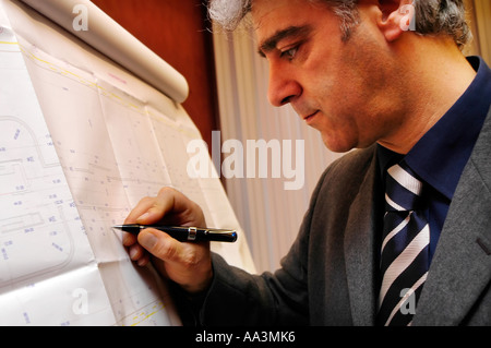 Male architect or engineer working on blueprints Stock Photo