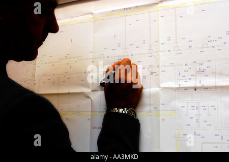 Silhouette of male engineer working in progress on blueprints Stock Photo