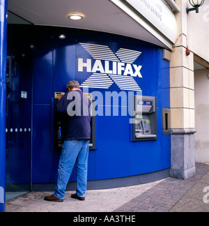 Rear back view of a man using the cash machine ATM outside  Halifax Building Society on a high street in Cardiff Wales UK Great Britain KATHY DEWITT Stock Photo