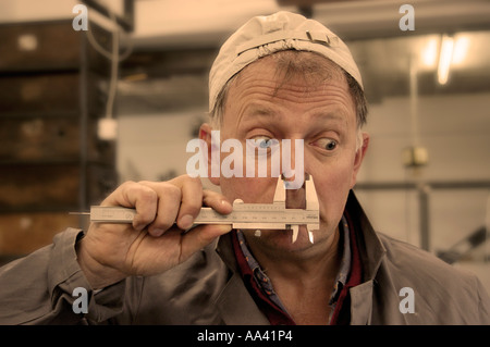Craftsman is clamping his nose in sliding caliper calliper Stock Photo