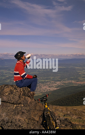 Mountain biker taking break above Smithers Bulkley Valley British Columbia Stock Photo