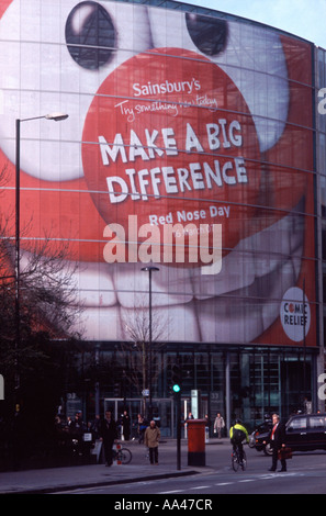 Comic Relief Red Nose Day publicity poster mounted inside glass curtain wall of Sainsbury's HQ, Holborn Circus, London Stock Photo