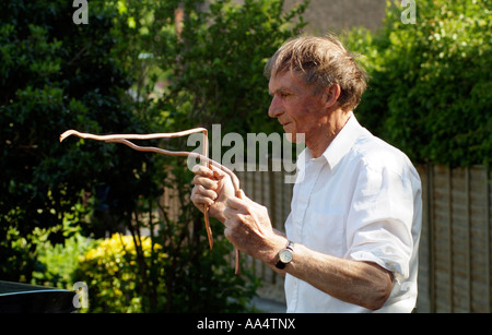 Water diviner Man using copper divining rods to trace water flow England UK Stock Photo
