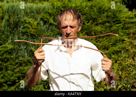 Water diviner.  Man using copper divining rods to trace water flow England UK Stock Photo