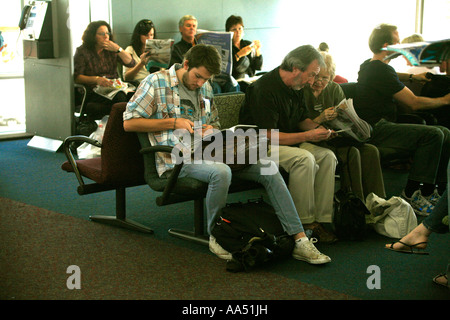 Passengers sit waiting for an airline connection at Mascot airport Sydney Australia Stock Photo