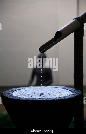 An asian style water feature which resonates as drops of water fall into a pool. Stock Photo