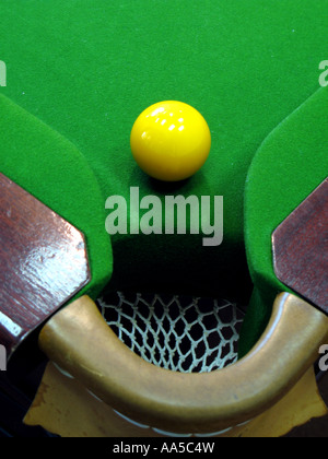 Yellow ball near the pocket on a snooker table Stock Photo