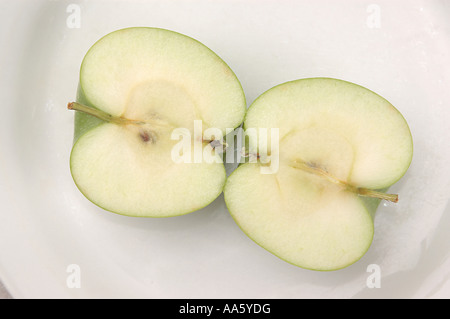 ANG103743 Food Fruit Green apple one full apple cut in to half apple on white plate Stock Photo