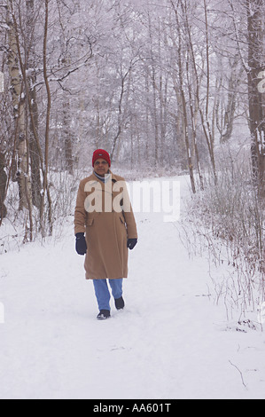ANG104041 Middle aged lady standing in forest covered with snow Sweden Model Release 468 Stock Photo
