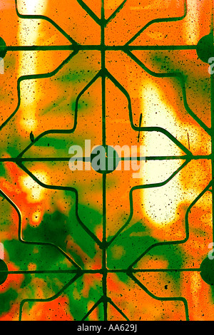 Window Iron grill abstract design protection safety protect flower four petals green orange Stock Photo