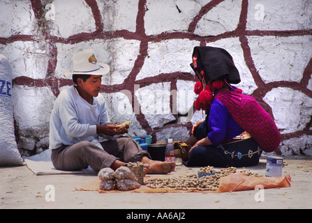 A ZINACANTAN MAYAN INDIAN COUPLE PREPARE BAGS OF MONKEY NUTS AT A MARKET IN SAN LORENZO ZINACANTAN CHIAPAS MEXICO Stock Photo