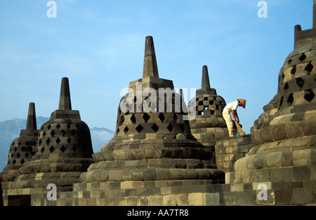 Cleaner sweeping up the stupas at Borobudur temple upper terraces, UNESCO World heritage site, Java, Indonesia Stock Photo