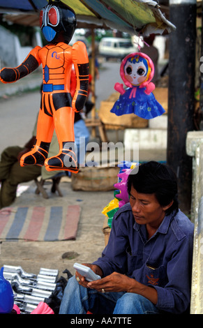 Street Vendor playing gameboy, Bukittinggi, Sumatra, Indonesia Stock Photo