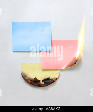 Burning paper stickers notes Urgent message reminder Stock Photo