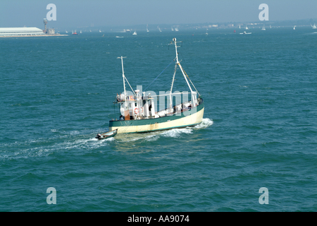 Old Fishing Boat Towing Dinghy in Southampton Water on The Solent Hampshire England United Kingdom UK Stock Photo