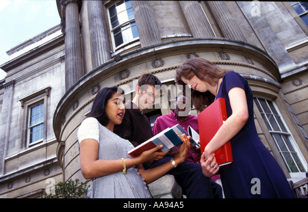 Group of university students standing chatting outside on campus. Stock Photo