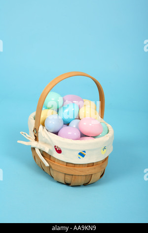 Easter basket full of pastel plastic eggs on blue background Stock Photo