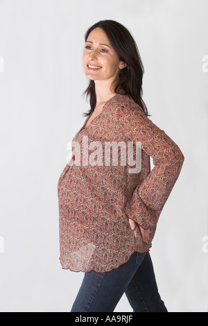 Pregnant Woman Wearing a Brown Patterned Smock Top and Jeans