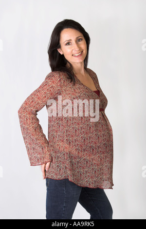 Pregnant Woman Wearing a Brown Patterned Smock Top and Jeans