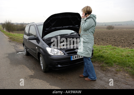 Woman with broken down car, UK Stock Photo