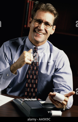 Portrait of a young businessman holding a print out from an adding machine Stock Photo