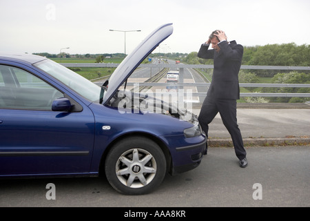 Car breakdown Businessman s car breakdown Checking under the hood Stock Photo