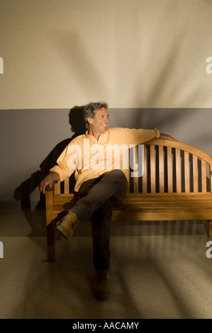 middle-aged man sitting on a bench in a building Stock Photo
