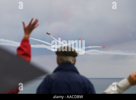 People watch Red Arrows flying display team one waving in excitement at Croyde Bay Devon England Stock Photo