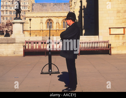 Bobby, police officer, standing alone on a London street. English constable or copper on the beat. Law enforcement England Stock Photo