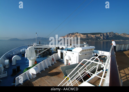 Coastline from bow of cruise ship off the coast of Sicily approaching Palermo early morning crew one passenger spectator Stock Photo