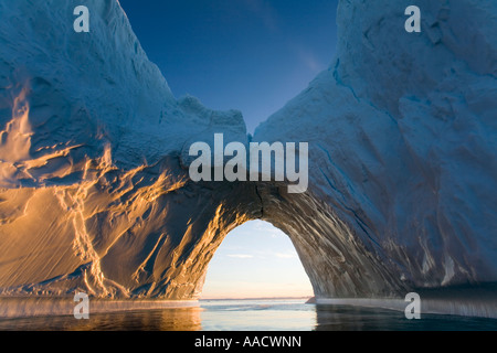 Greenland Ilulissat Setting midnight sun lights massive arched iceberg from Ilulissat Kangerlua Glacier Jakobshavn Icefjord floa Stock Photo