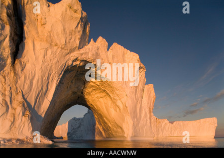 Greenland Ilulissat Setting midnight sun lights massive arched iceberg from Ilulissat Kangerlua Glacier Jakobshavn Icefjord floa Stock Photo