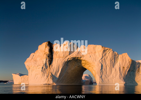 Greenland Ilulissat Setting midnight sun lights massive arched iceberg from Ilulissat Kangerlua Glacier Jakobshavn Icefjord floa Stock Photo