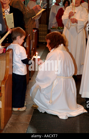 Revd Anne Le Bas lighting candles in the congregation Stock Photo