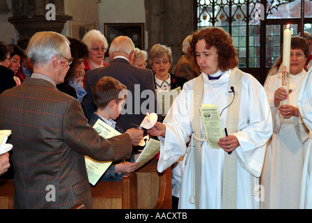 Revd Anne Le Bas lighting candles in the congregation Stock Photo