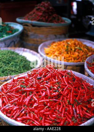 An abundance of colourful fresh chillies on display in baskets at a street market in the heart of Bangkok, Thailand Stock Photo