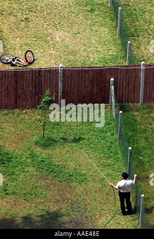 Man watering a tree on his back garden London England Britain UK Stock Photo
