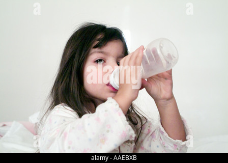 Little girl peacefully drinks her morning drink of  milk Stock Photo