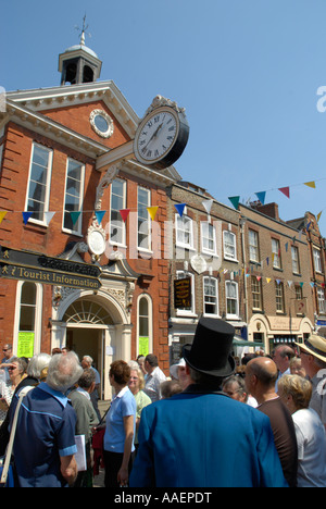 Man dressed in Dickensian costume with visitors outside Old Corn Exchange during  the Dickens Festival Rochester Kent England Stock Photo