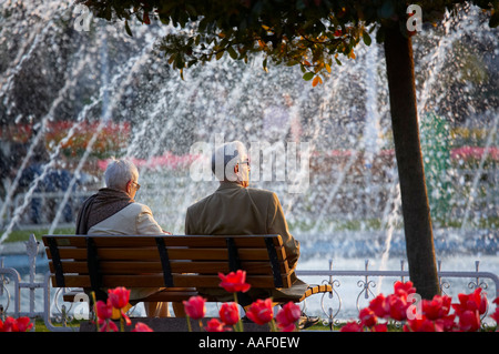 a senior couple relaxing on a park bench by the fountains in Sultanahmet Square Istanbul Turkey NR Stock Photo